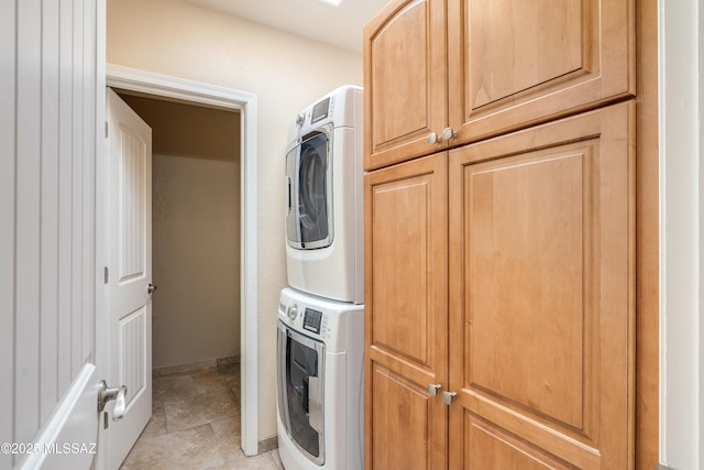 6261 N Placita De Rojelio, Tucson, AZ 85718 - washroom featuring estacked washer and dryer, cabinet space, baseboards, and light tile patterned floors