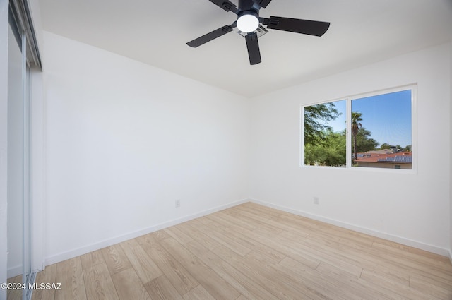 empty room with baseboards, a ceiling fan, and wood finished floors