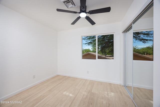 spare room with baseboards, ceiling fan, wood finished floors, and visible vents