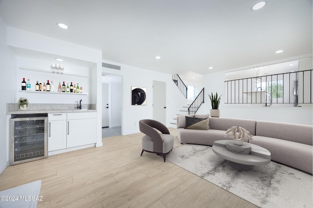 living room with wet bar, visible vents, beverage cooler, stairs, and light wood-style flooring