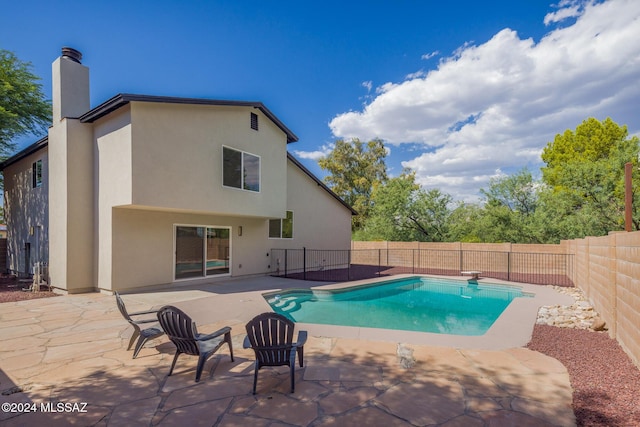 view of swimming pool with a fenced in pool, a fenced backyard, a patio area, and a diving board