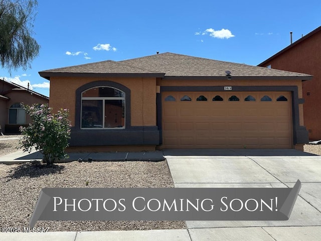 view of front of property featuring an attached garage, a shingled roof, stucco siding, and concrete driveway