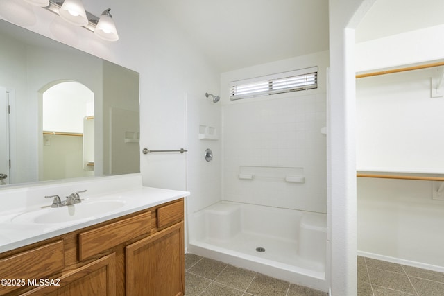 2414 E Calle Lena Verde, Tucson, AZ 85706 - bathroom featuring a walk in closet, vanity, and a stall shower