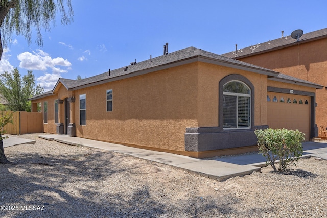 2414 E Calle Lena Verde, Tucson, AZ 85706 - view of side of home with a garage, stucco siding, and driveway
