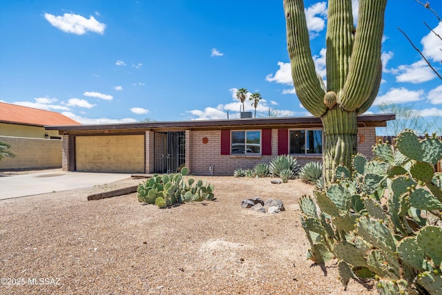 9770 E Hollow Pl, Tucson, AZ 85748 - ranch-style house with brick siding, an attached garage, and concrete driveway