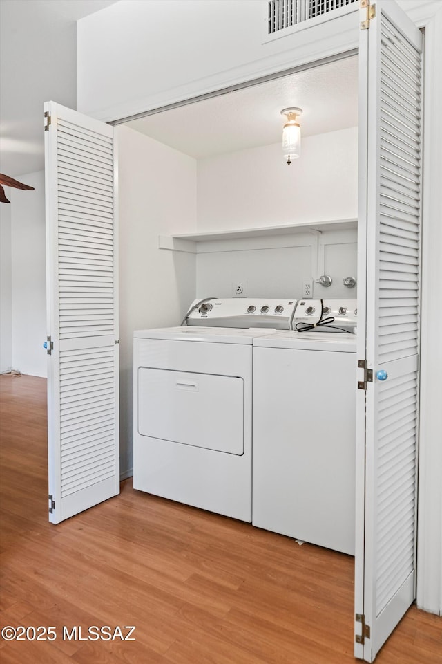 9770 E Hollow Pl, Tucson, AZ 85748 - laundry room with visible vents, light wood-style floors, a ceiling fan, washer and dryer, and laundry area