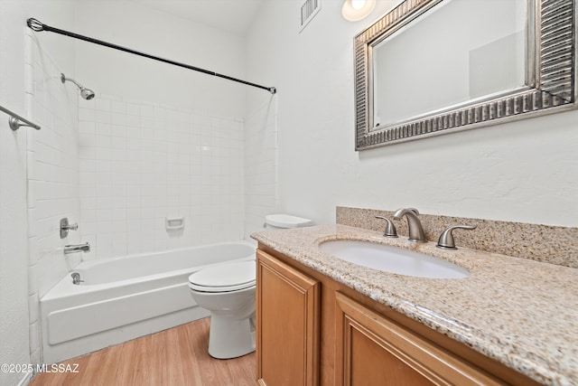 9770 E Hollow Pl, Tucson, AZ 85748 - bathroom featuring wood finished floors, visible vents, toilet, vanity, and bathtub / shower combination
