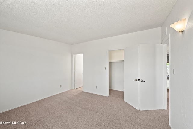 9770 E Hollow Pl, Tucson, AZ 85748 - unfurnished bedroom featuring a spacious closet, carpet floors, and a textured ceiling