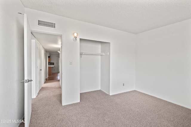 9770 E Hollow Pl, Tucson, AZ 85748 - unfurnished bedroom with a textured ceiling, visible vents, carpet, and a closet
