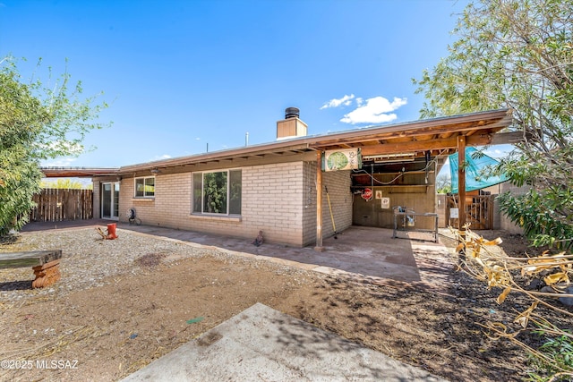 9770 E Hollow Pl, Tucson, AZ 85748 - back of house with a chimney, fence, and brick siding
