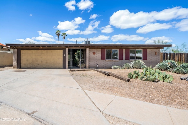 9770 E Hollow Pl, Tucson, AZ 85748 - ranch-style home with brick siding, an attached garage, fence, and driveway