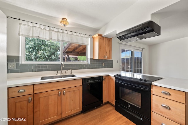 9770 E Hollow Pl, Tucson, AZ 85748 - kitchen with under cabinet range hood, a sink, light wood-style floors, decorative backsplash, and black appliances