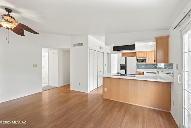 9770 E Hollow Pl, Tucson, AZ 85748 - kitchen featuring a sink, white fridge with ice dispenser, light wood finished floors, stainless steel microwave, and visible vents