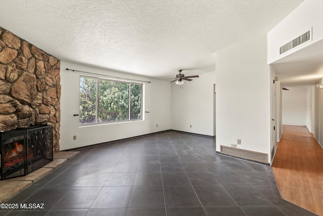 9770 E Hollow Pl, Tucson, AZ 85748 - unfurnished living room with ceiling fan, tile patterned flooring, a stone fireplace, and visible vents