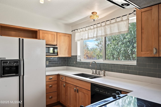9770 E Hollow Pl, Tucson, AZ 85748 - kitchen featuring black appliances, brown cabinets, tasteful backsplash, and a sink