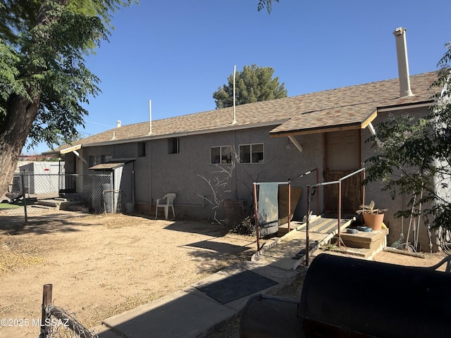 276 E Pastime Rd, Tucson, AZ 85705 - rear view of property with fence, roof with shingles, and stucco siding