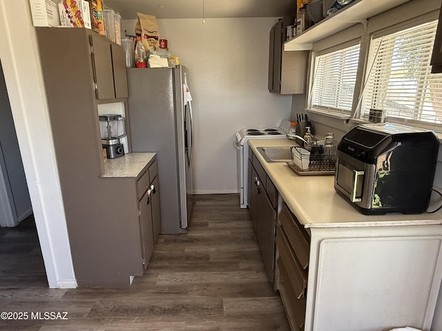 276 E Pastime Rd, Tucson, AZ 85705 - kitchen featuring white range with electric cooktop, dark wood-style flooring, freestanding refrigerator, and light countertops
