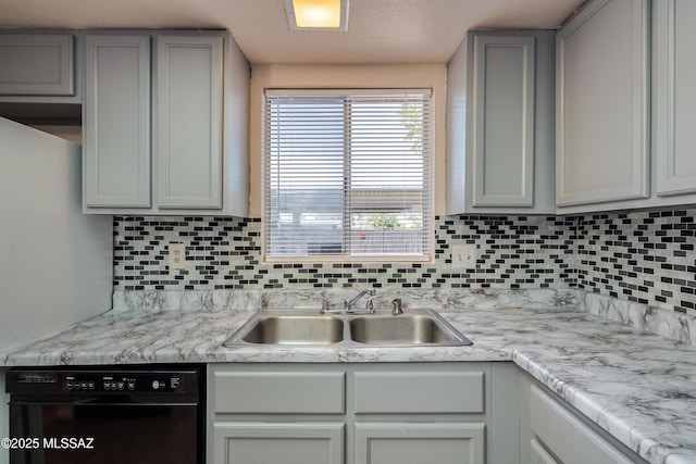kitchen with light countertops, dishwasher, decorative backsplash, and a sink