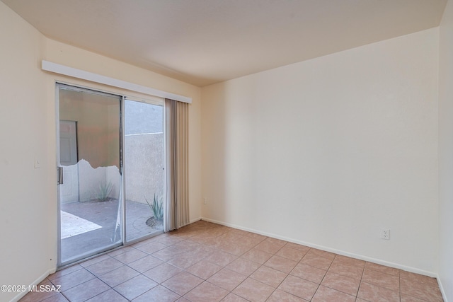 empty room featuring baseboards and light tile patterned flooring
