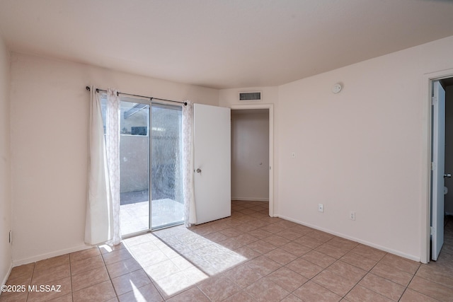 unfurnished room with visible vents, baseboards, and light tile patterned floors