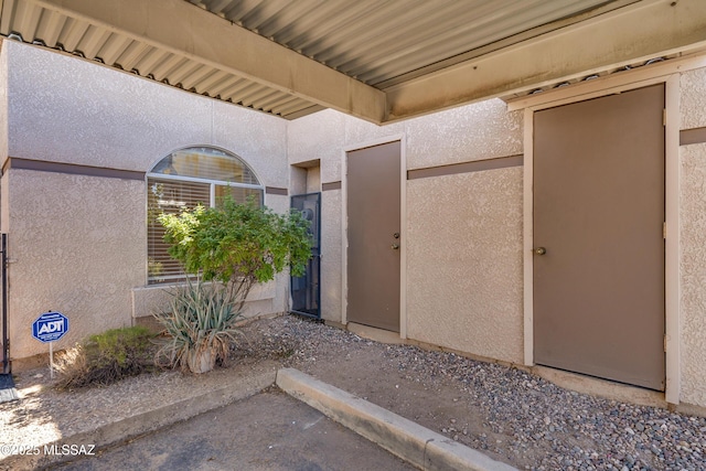 property entrance with stucco siding