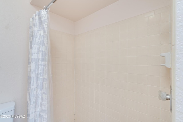full bath featuring a tile shower and toilet