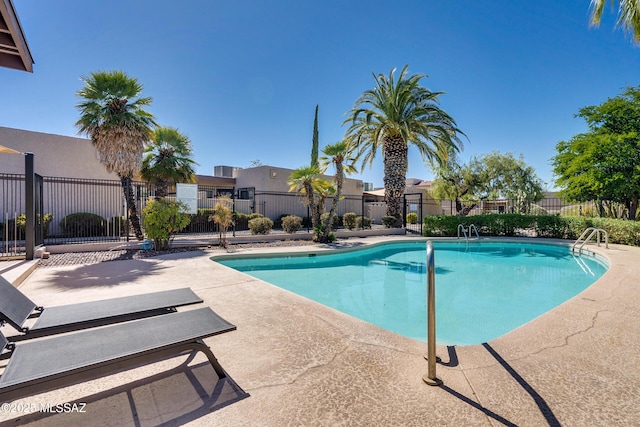 community pool featuring a residential view, a patio area, and fence