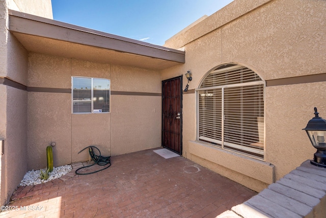 view of exterior entry featuring stucco siding