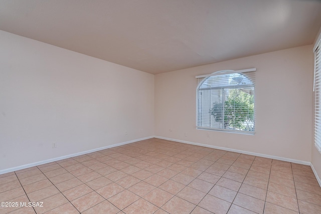 unfurnished room with baseboards
