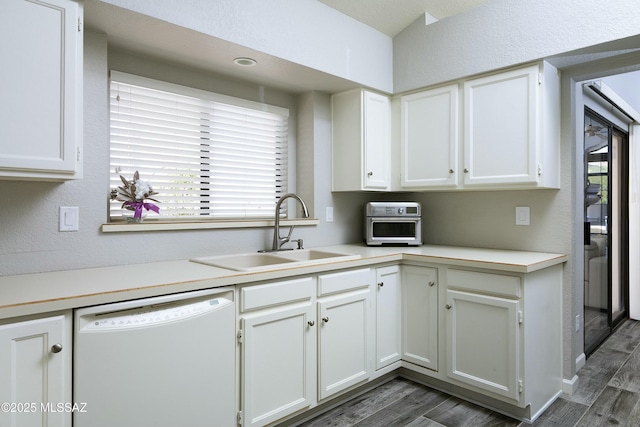 9810 E Amaroso Ln, Tucson, AZ 85748 - kitchen featuring light countertops, white dishwasher, dark wood-style flooring, a sink, and white cabinetry
