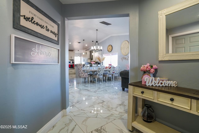 hall featuring lofted ceiling, visible vents, baseboards, a notable chandelier, and marble finish floor