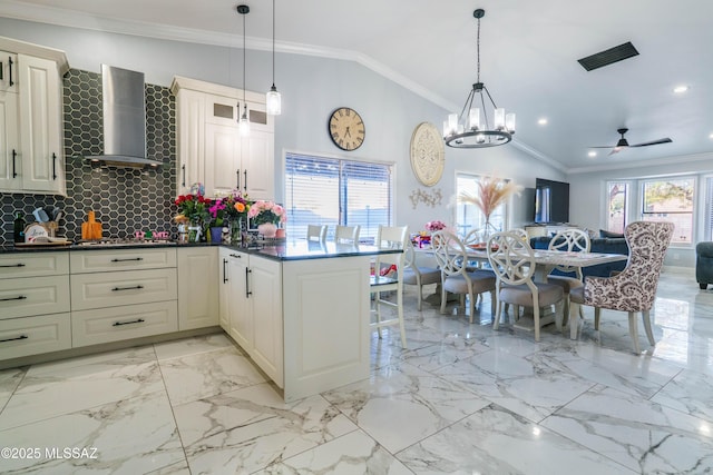 kitchen featuring decorative backsplash, visible vents, open floor plan, vaulted ceiling, and wall chimney exhaust hood