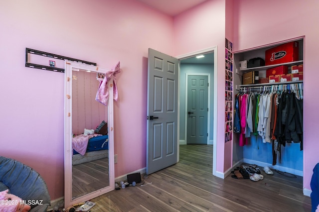 bedroom featuring a closet, wood finished floors, and baseboards