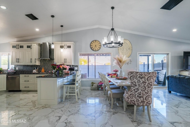 dining area featuring a chandelier, lofted ceiling, and marble finish floor