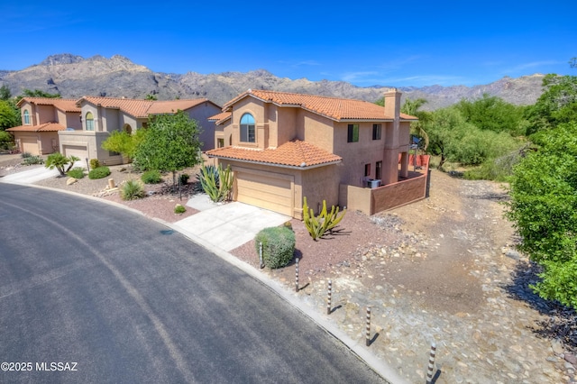 5476 N Indian Trl, Tucson, AZ 85750 - mediterranean / spanish-style home with a tiled roof, a mountain view, a chimney, an attached garage, and stucco siding