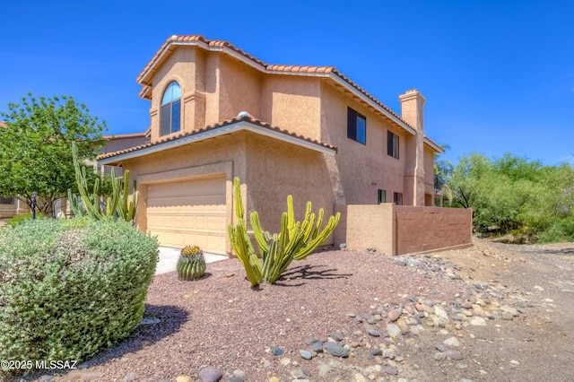 5476 N Indian Trl, Tucson, AZ 85750 - view of side of property featuring stucco siding, a tile roof, a chimney, and a garage