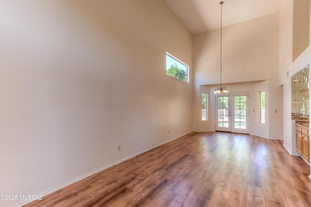 5476 N Indian Trl, Tucson, AZ 85750 - interior space featuring light wood finished floors, baseboards, a towering ceiling, and an inviting chandelier