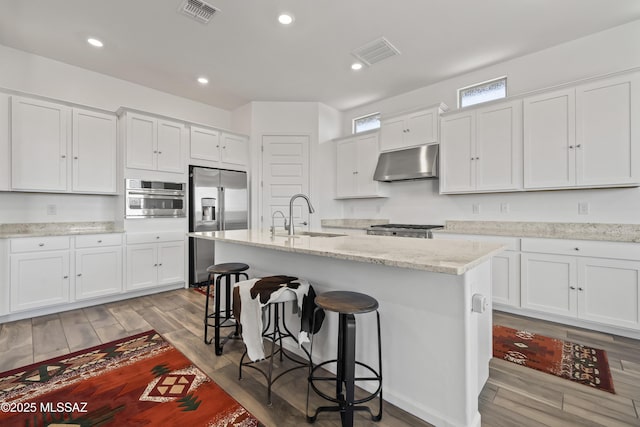 kitchen with a sink, visible vents, appliances with stainless steel finishes, and under cabinet range hood