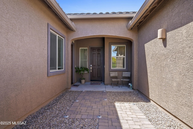 entrance to property featuring stucco siding