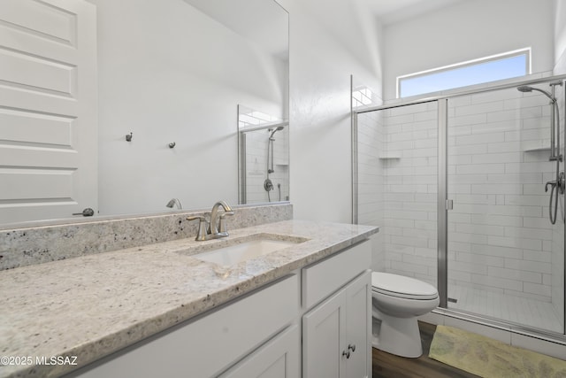 full bath featuring vanity, toilet, and a stall shower