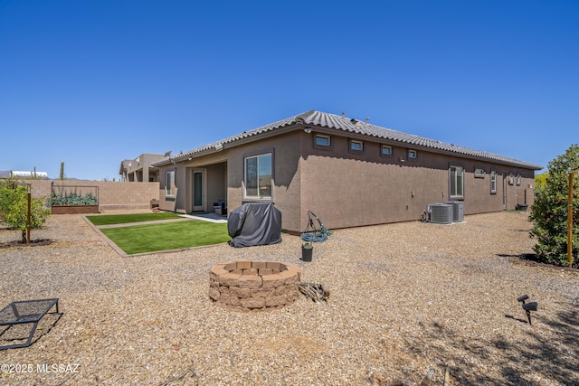 back of house featuring stucco siding, a fire pit, fence, a patio, and central AC