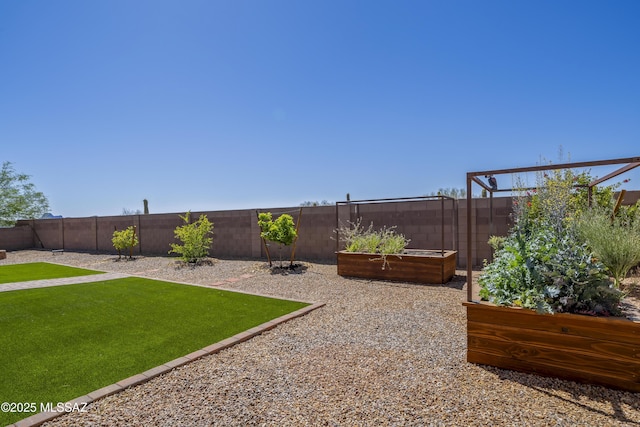 view of yard featuring a garden and a fenced backyard