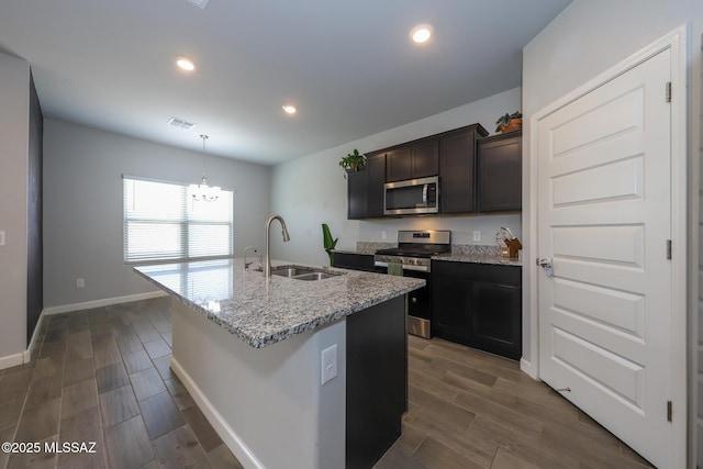 491 W Camino Del Toro, Vail, AZ 85641 - kitchen with stainless steel appliances, a sink, dark wood-style floors, a center island with sink, and light stone counters