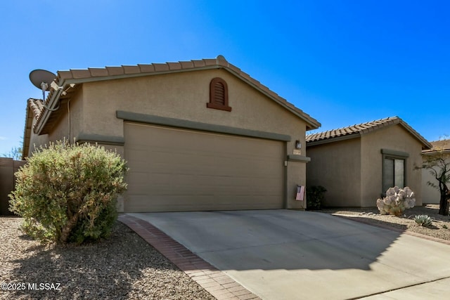 10658 E Rose Hill St, Tucson, AZ 85747 - view of front of property with stucco siding, an attached garage, concrete driveway, and a tiled roof