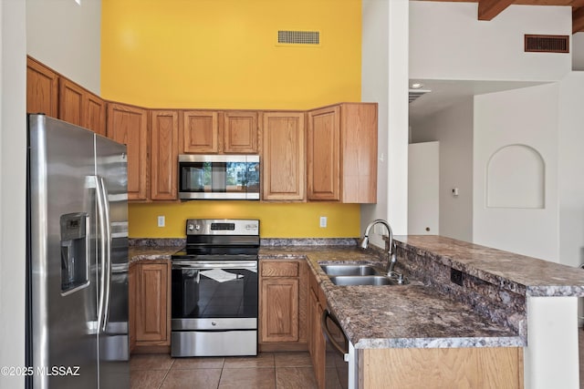 kitchen featuring light tile patterned floors, appliances with stainless steel finishes, a sink, and visible vents