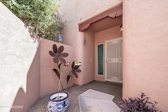 doorway to property featuring stucco siding