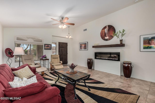5354 W Eagle Claws Ct, Marana, AZ 85658 - living area with ceiling fan, visible vents, a glass covered fireplace, vaulted ceiling, and tile patterned floors