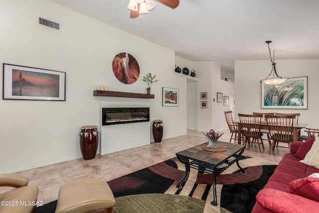 5354 W Eagle Claws Ct, Marana, AZ 85658 - tiled living room featuring visible vents, ceiling fan, and a glass covered fireplace