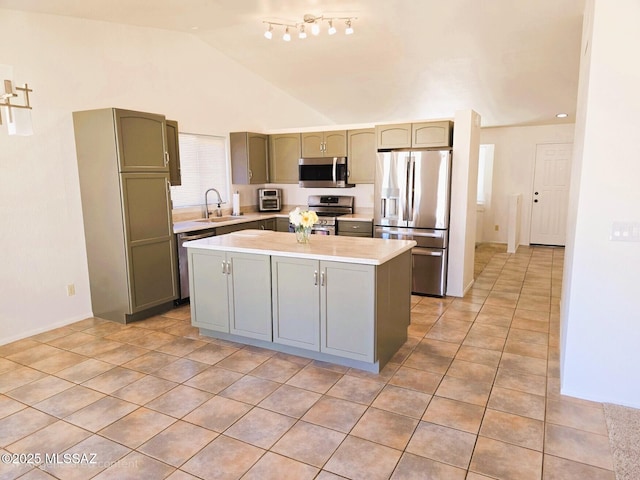 kitchen featuring stainless steel appliances, a sink, light tile patterned flooring, lofted ceiling, and light countertops