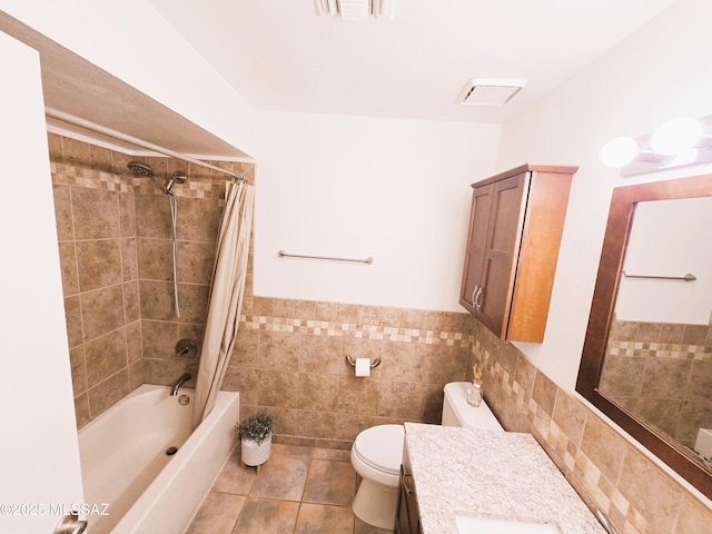 bathroom with tile patterned floors, toilet, vanity, shower / tub combo with curtain, and tile walls